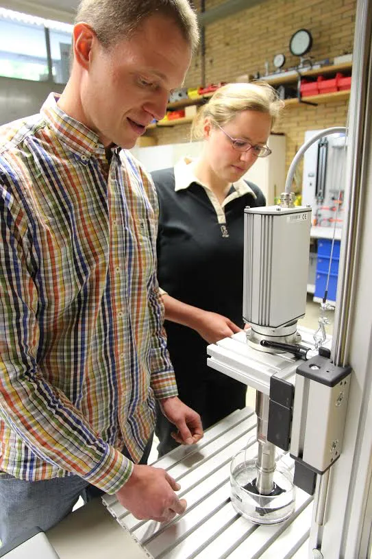 Die Wissenschaftlichen Mitarbeiter Daniel Seipp und Miriam Dill untersuchen die Haftfähigkeit der Beschichtung mit einem Ultraschallgenerator, der etwa 20.000 Schwingungen pro Sekunde erzeugt. Foto: TH Mittelhessen