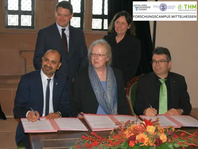 Die Gründung des Forschungscampus Mittelhessen: Prof. Joybrato Mukherjee, JLU Gießen (l.), Prof. Katharina Krause, Universität Marburg (Mitte), Prof. Mathias Willems, THM, (r.), im Beisein von Minister Boris Rhein und Prof. Katja Becker, DFG (stehend)