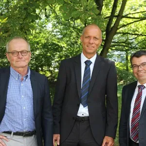 Prof. Degünther (Mitte) mit THM-Präsident Prof. Matthias Willems (rechts) und Ralf Niggemann von Wetzlar Network.